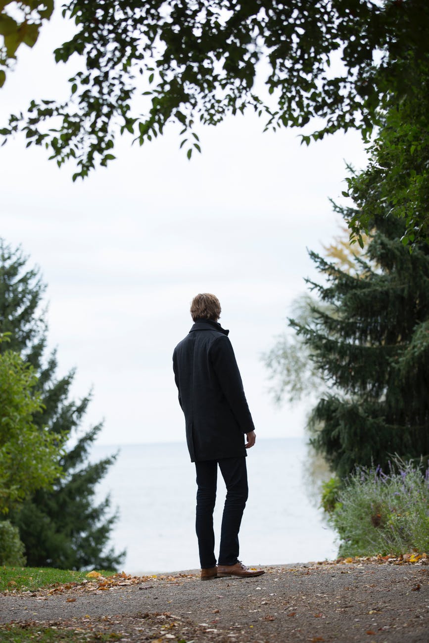 man standing in the middle of empty road